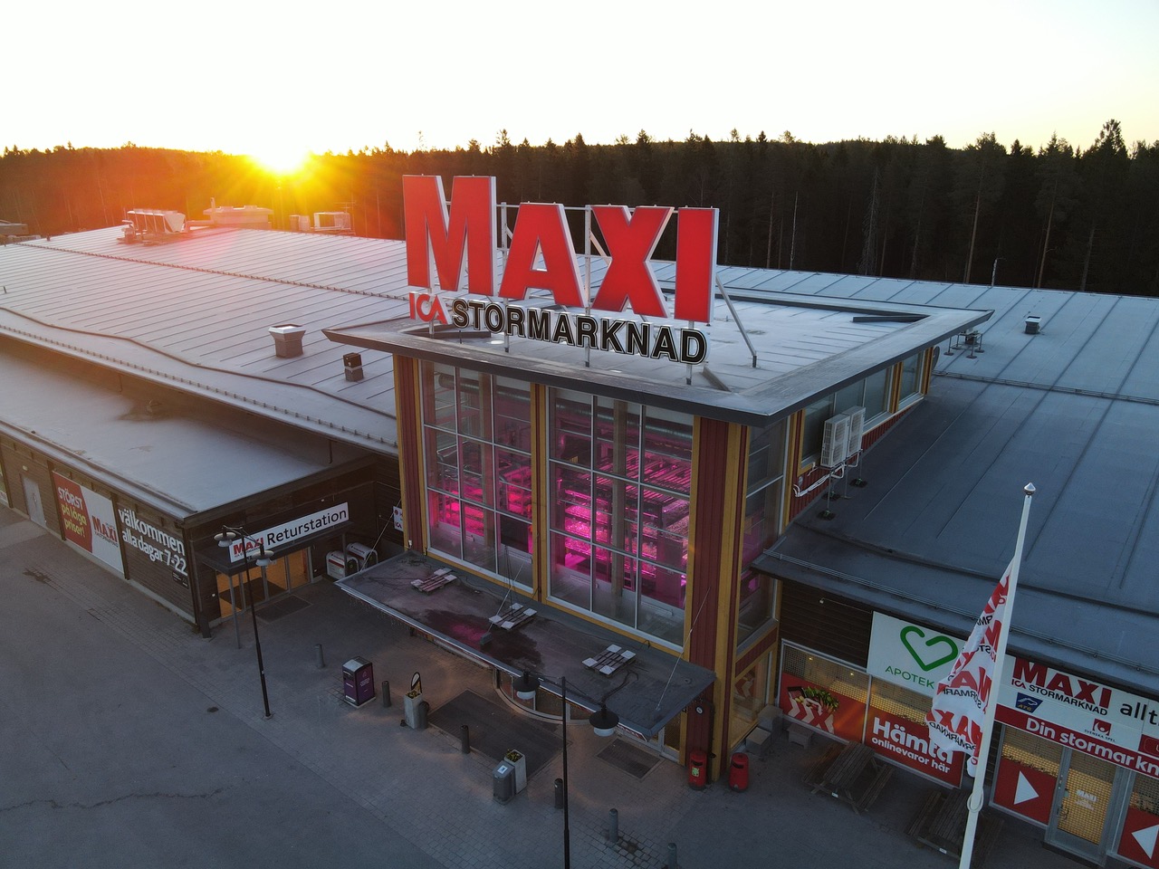 ICA Maxi Skellefteå i solnedgång, entrétornet lyser rosa av odlingen